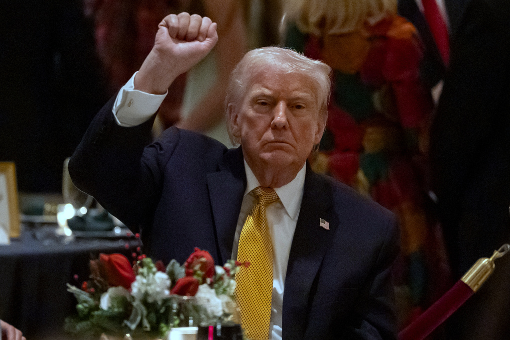 President Donald Trump pumps his fist at Christmas Eve dinner at his Mar-a-Lago club, Wednesday, Dec. 24, 2025, in Palm Beach, Fla. (AP Photo/Alex Brandon)