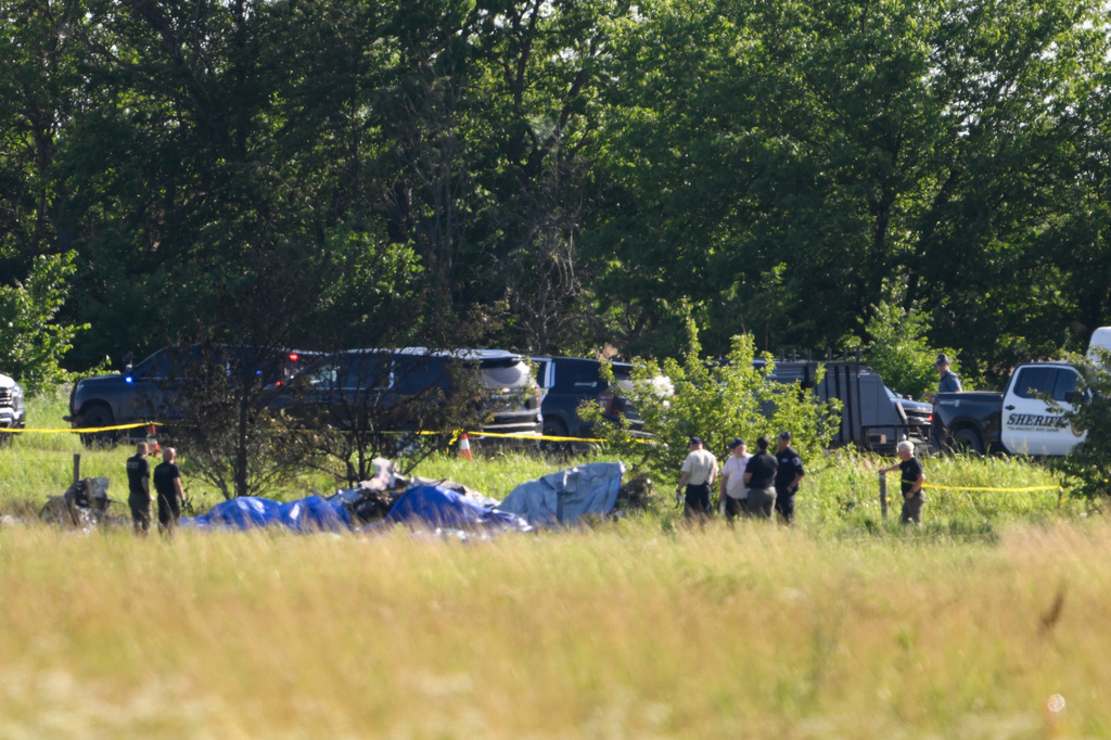 Emergency personnel investigate the site of a plane crash at the Butler Memorial Airport in Butler, Mo., Sunday, June 14, 2026. (AP Photo/Reed Hoffmann)