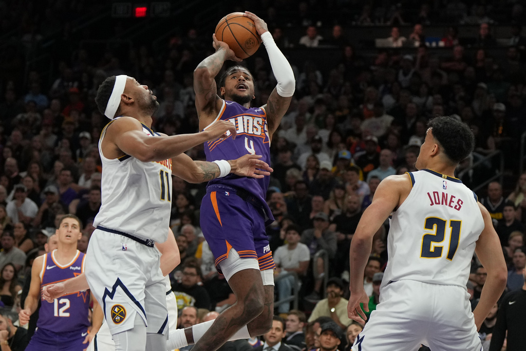 Phoenix Suns guard Jalen Green (4) shoots over Denver Nuggets guard Bruce Brown and forward Spencer Jones (21) during the first half of an NBA basketball game, Tuesday, March 24, 2026, in Phoenix. (AP Photo/Rick Scuteri)