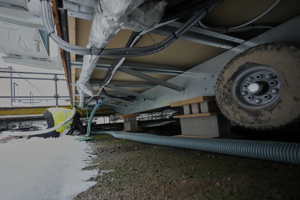 Workers pull cables in the athlete's village for the Cortina Milan Winter Olympics, in Cortina D'Ampezzo, Italy, Monday, Nov. 24, 2025. (AP Photo/Andrew Medichini)