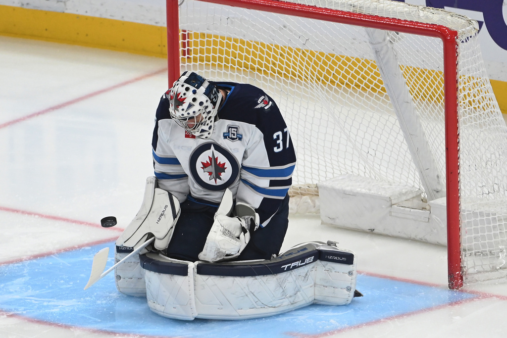 The puck makes it past Winnipeg Jets goalie Connor Hellebuyck (37) for a goal by Pittsburgh Penguins right wing Egor Chinakhov during the first period in an NHL hockey game, Saturday, March 21, 2026, in Pittsburgh. (AP Photo/Philip G. Pavely)