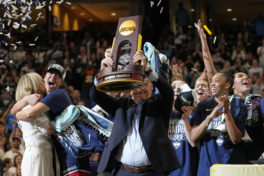 UConn head coach Geno Auriemma holds up the championship trophy after UConn defeated South Carolina in the national championship game at the Final Four of the women's NCAA college basketball tournament, Sunday, April 6, 2025, in Tampa, Fla. (AP Photo/Chris O'Meara)