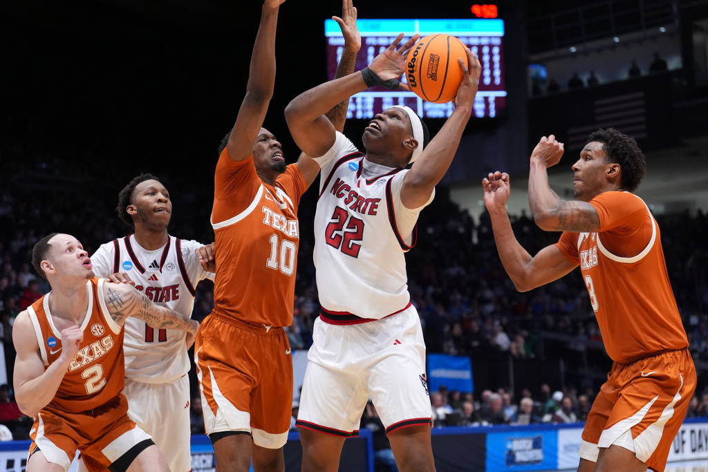 North Carolina State forward Ven-Allen Lubin (22), center, goes up for a shot as Texas forward Nic Codie (10), left, and Texas forward Dailyn Swain (3), right, defend during the first half in a First Four college basketball game in the NCAA Tournament, Tuesday, March 17, 2026, in Dayton, Ohio. (AP Photo/Kareem Elgazzar)