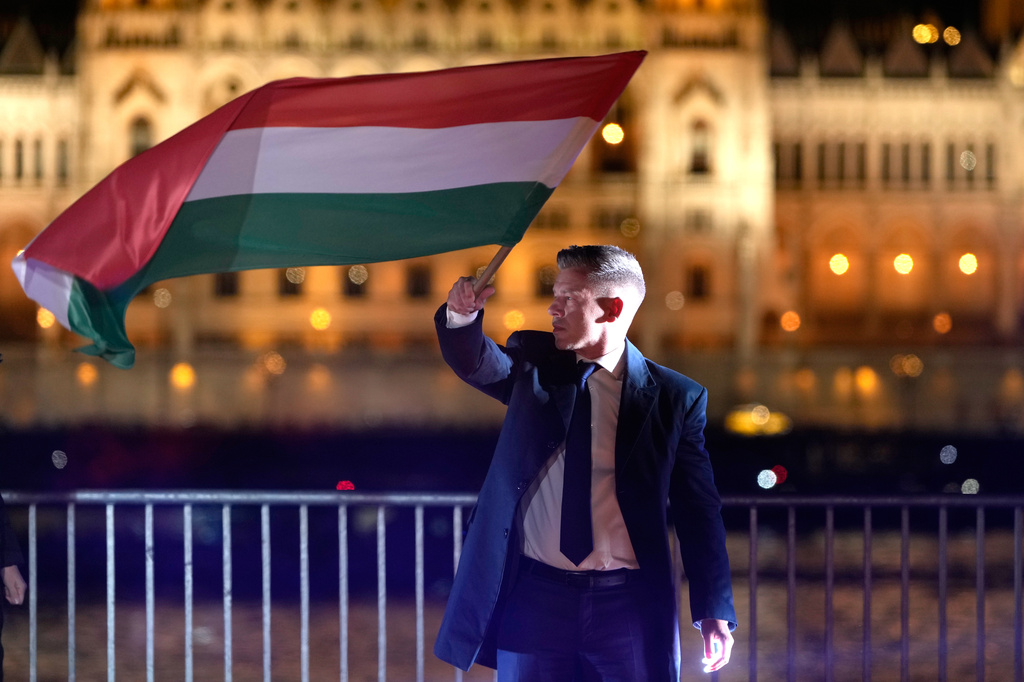 Peter Magyar, the leader of the opposition Tisza party waves a national flag after a parliamentary election in Budapest, Hungary, Sunday, April 12, 2026. (AP Photo/Darko Bandic)