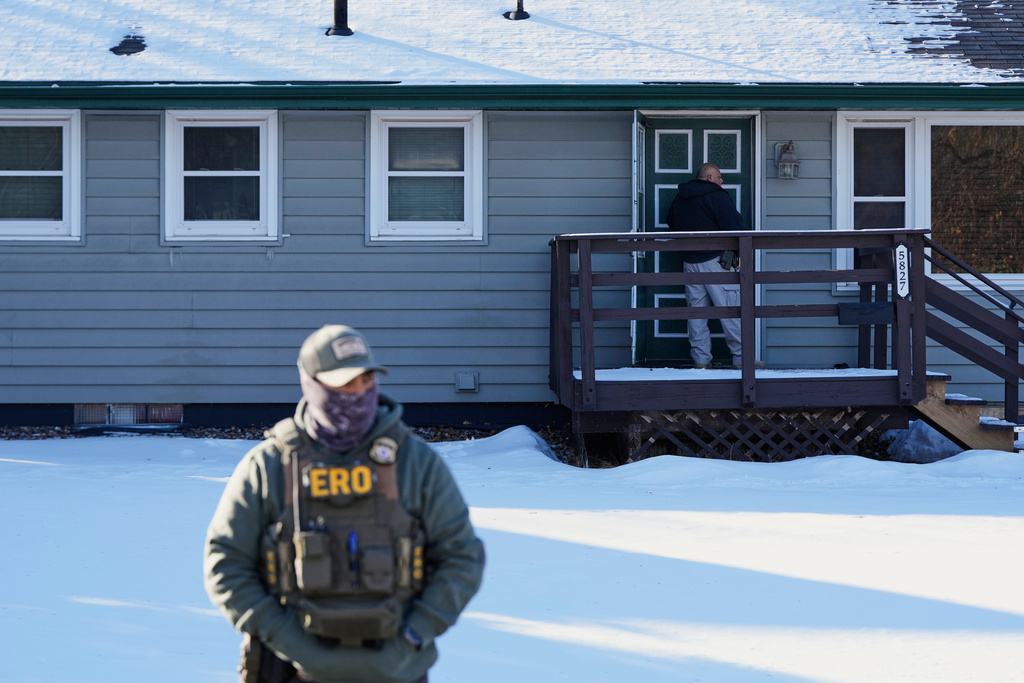 A federal immigration officer knocks on the door of a residence Wednesday, Jan. 28, 2026, in Brooklyn Center, Minn. (AP Photo/Julia Demaree Nikhinson)