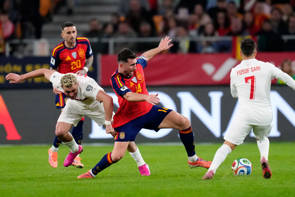 Turkey's Barış Alper Yılmaz fights for the ball against Spain's Aymeric Laporte during the 2026 World Cup qualifier group E soccer match between Spain and Turkey in Seville, Spain, Tuesday, Nov. 18, 2025. (AP Photo/Jose Breton)