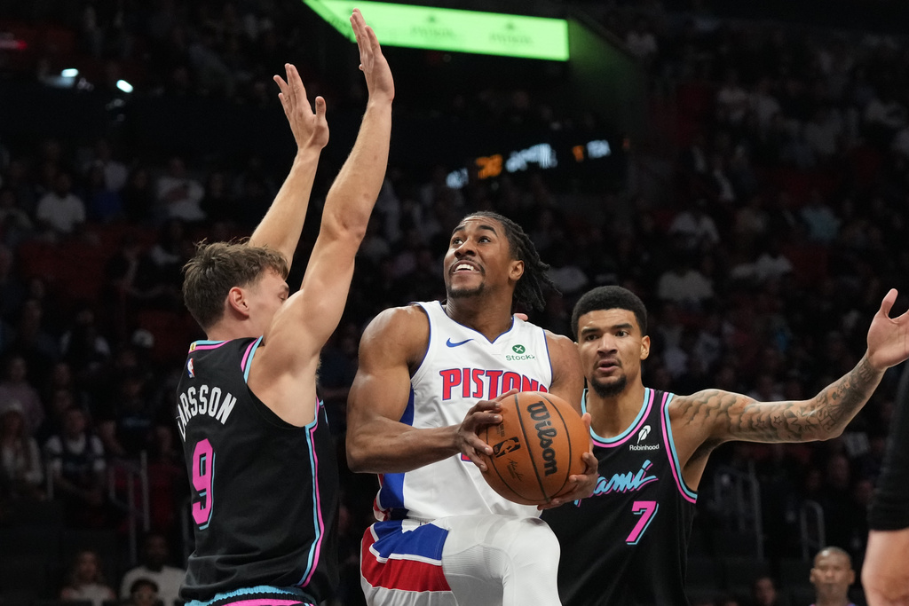 Detroit Pistons guard Jaden Ivey (23) aims to score as Miami Heat guard Pelle Larsson (9) and center Kel'el Ware (7) defend during the first half of an NBA basketball game Saturday, Nov. 29, 2025, in Miami. (AP Photo/Marta Lavandier)