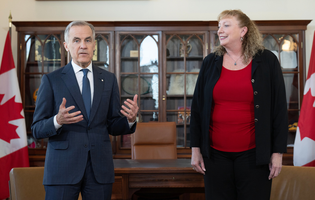 Prime Minister Mark Carney delivers some remarks as MP for Sarnia-Lambton-Bkejwanong Marilyn Gladu looks on during an event in his office in Ottawa, Wednesday, April 8, 2026. (Adrian Wyld /The Canadian Press via AP)