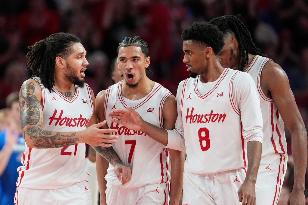 FILE - Houston's Emanuel Sharp (21), Milos Uzan (7) and Mylik Wilson (8) celebrate during a timeout against Kansas during the second half of an NCAA college basketball game Monday, March 3, 2025, in Houston. (AP Photo/David J. Phillip, File)