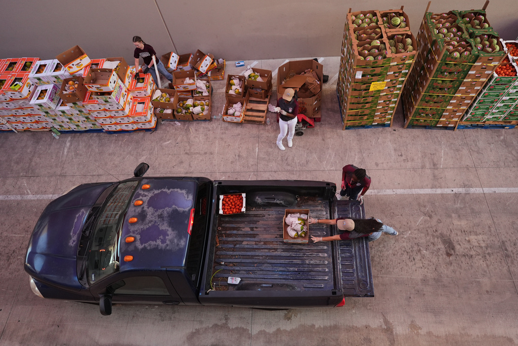 Volunteers help load vehicles during a food distribution at the San Antonio Food Bank for SNAP recipients and other households affected by the federal shutdown, Thursday, Nov. 6, 2025, in San Antonio. (AP Photo/Eric Gay)