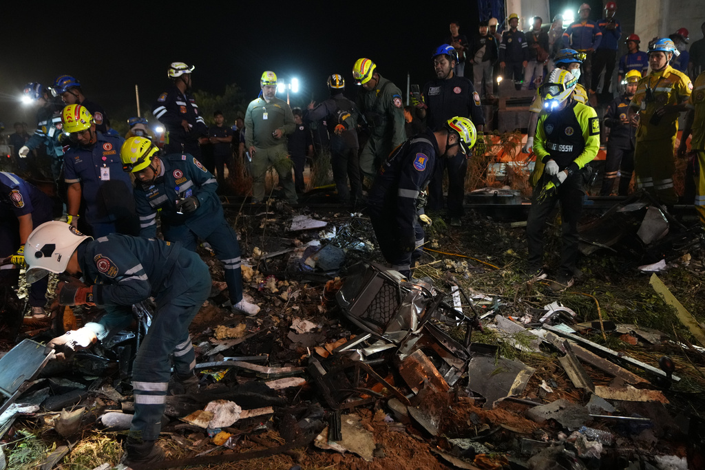 Rescuers inspects the wreckage after a construction crane fell onto a passenger train in Nakhon Ratchasima province, Thailand, Wednesday, Jan. 14, 2026. (AP Photo/Sakchai Lalit)