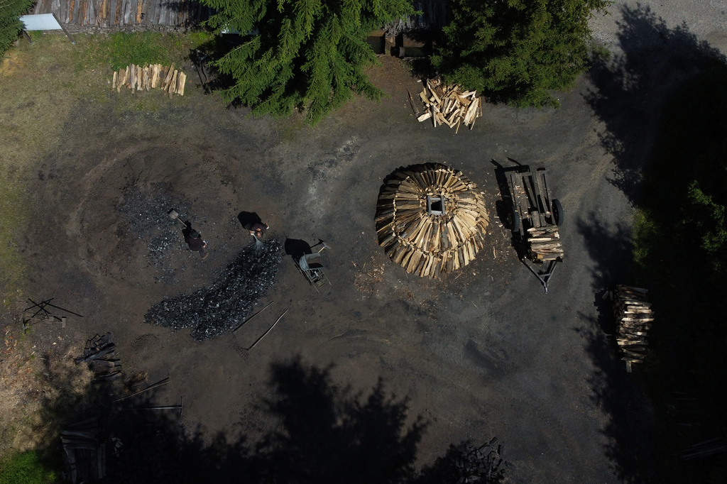 Brothers Immo and Sascha Feldmer work at their family-run, traditional charcoal production site near Hasselfelde in Germany's Harz forest, Saturday, July 11, 2026. (AP Photo/Matthias Schrader)