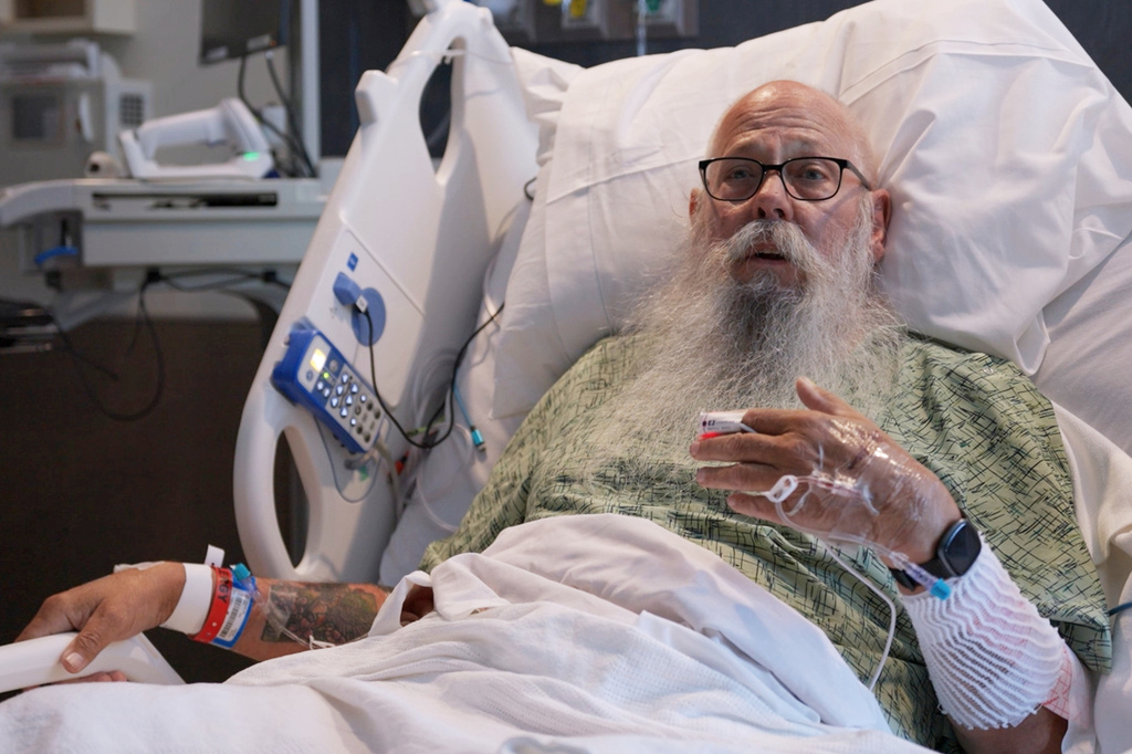 This image taken from Bozeman Health video shows Carl McDaniel speaking from in a hospital bed at Bozeman Health on July, 13, 2026, in Bozeman Mont., after he was hit by a bison in Yellowstone National Park. (Bozeman Health via AP)