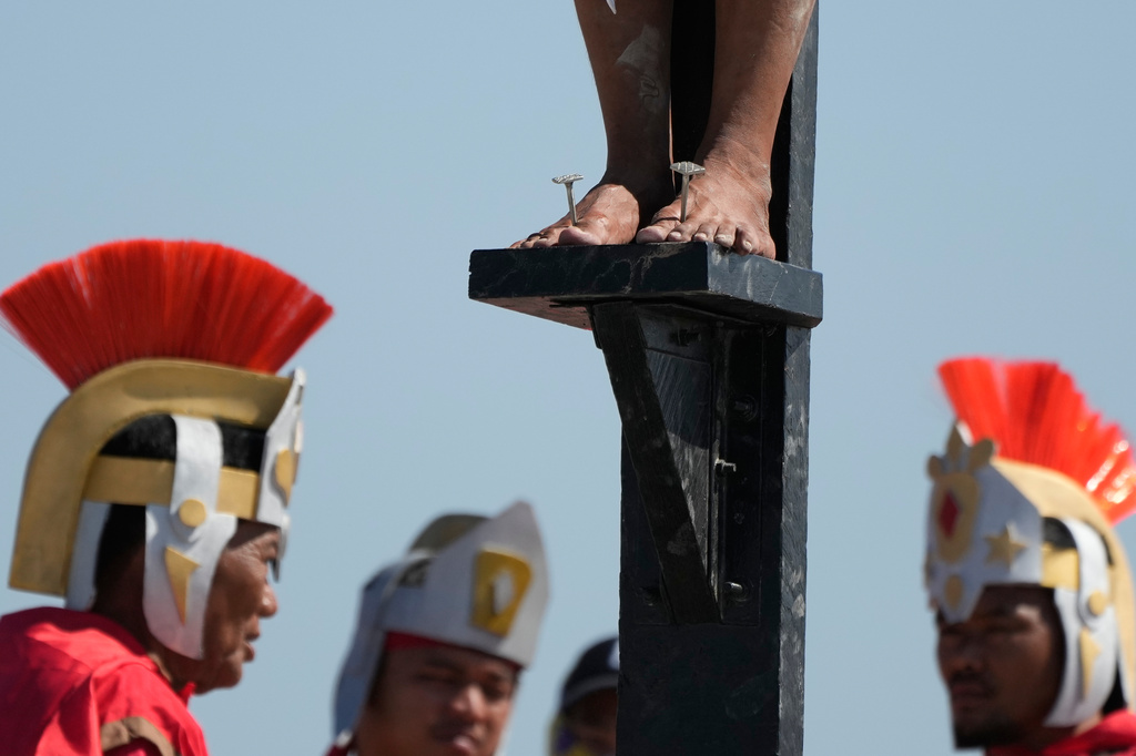 A nail is pierced on the feet of Arnold Manaigo during the reenactment of Jesus Christ's sufferings as part of Good Friday rituals in the San Pedro Cutud village, Pampanga province, northern Philippines April 3, 2026. (AP Photo/Aaron Favila)