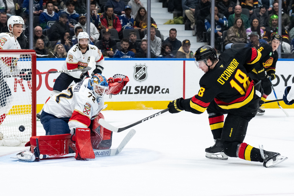 Vancouver Canucks' Drew O'Connor (18) scores on Florida Panthers goaltender Sergei Bobrovsky (72) during the third period of an NHL hockey game in Vancouver, on Tuesday, March 17, 2026. (Ethan Cairns/The Canadian Press via AP)