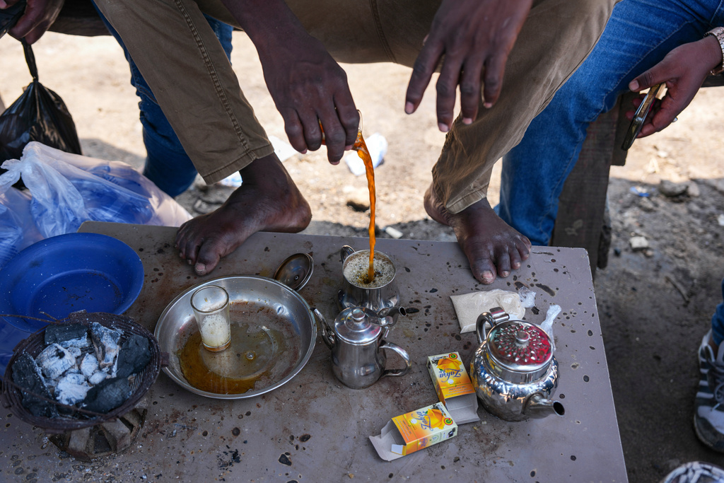 Tanane Ibrahim prepare tea at a livestock market in Abidjan, Ivory Coast, Friday, Oct. 24, 2025. (AP Photo/Misper Apawu)