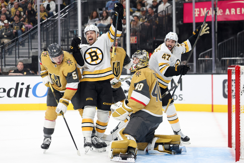 Boston Bruins left wing Jeffrey Viel (48) and center Mark Kastelic (47) celebrate after their team's goal while Vegas Golden Knights defenseman Jeremy Lauzon (5) and goaltender Akira Schmid (40) reacts during the first period of an NHL hockey game Thursday, Oct. 16, 2025, in Las Vegas. (AP Photo/Ian Maule)