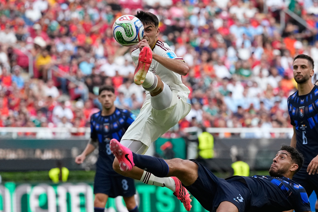 Spain's Pedri, top, and Uruguay's Sebastian Caceres vie for the ball during the World Cup Group H soccer match between Uruguay and Spain in Zapopan, near Guadalajara, Mexico, Friday, June 26, 2026. (AP Photo/Natacha Pisarenko)