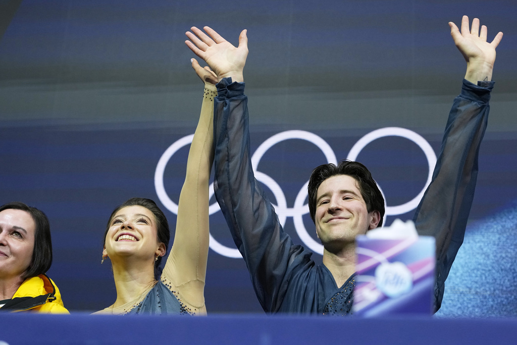 Anastasiia Golubeva and Hektor Giotopoulos Moore of Australia wait for scores after competing, during the pairs figure skating short program at the 2026 Winter Olympics, in Milan, Italy, Sunday, Feb. 15, 2026. (AP Photo/Natacha Pisarenko)