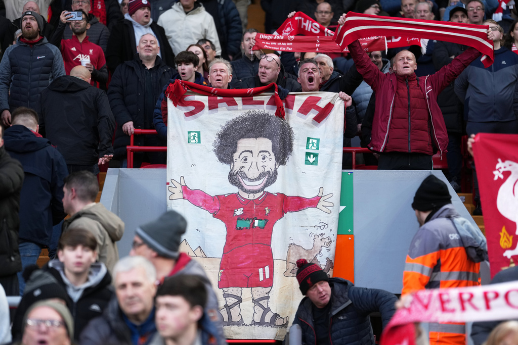 Liverpool fans hold placard depicting Liverpool's Mohamed Salah before the English Premier League soccer match between Liverpool and Brighton and Hove Albion in Liverpool, England, Saturday, Dec. 13, 2025. (AP Photo/Jon Super)