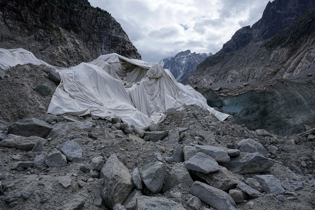 Tarpaulins cover the ice cave of the 'Mer de Glace' glacier to prevent it from melting, at the Montenvers station in Chamonix, France, Saturday, Sept. 5, 2026. (AP Photo/Laurent Cipriani)