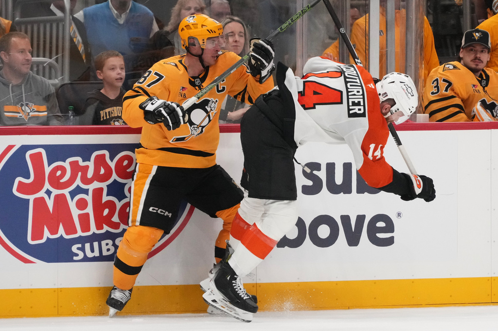 Pittsburgh Penguins' Sidney Crosby (87) checks Philadelphia Flyers' Sean Couturier, right, off his skates during the second period of Game 1 in the first round of the NHL Stanley Cup playoffs in Pittsburgh, Saturday, April 18, 2026. (AP Photo/Gene J. Puskar)