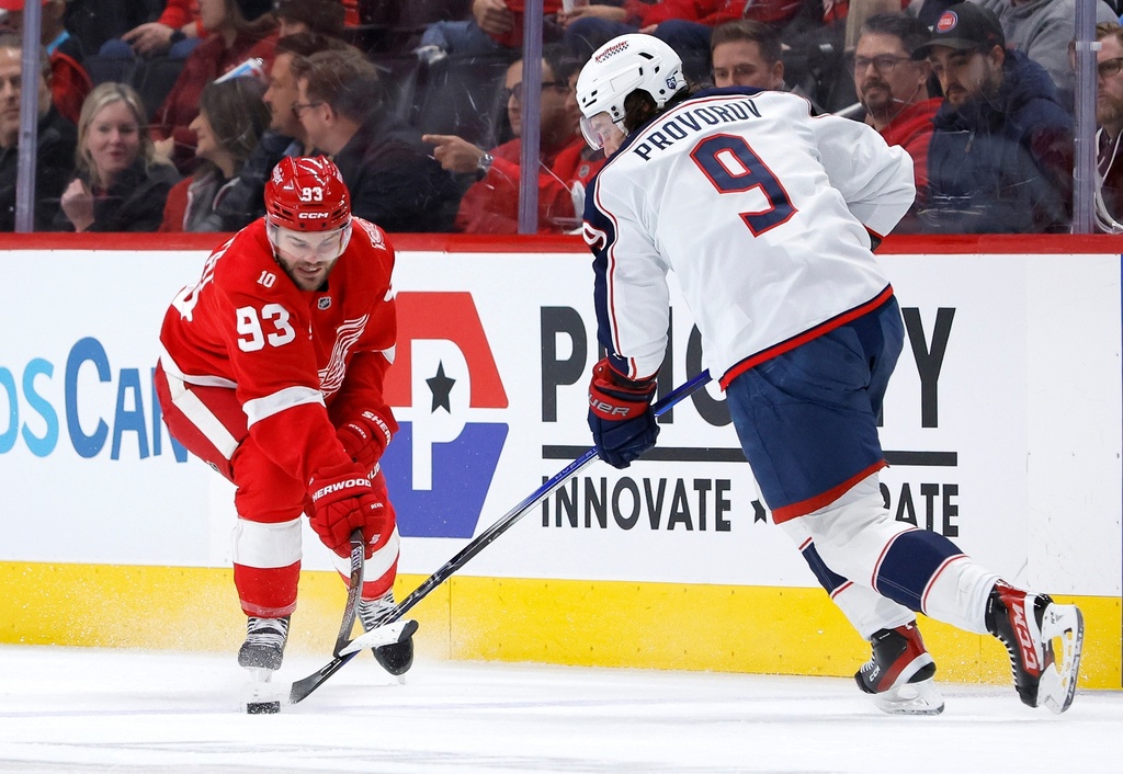 Detroit Red Wings right wing Alex Debrincat (93) tries to steal the puck from Columbus Blue Jackets defenseman Ivan Provorov (9) during the first period of an NHL hockey game Saturday, Nov. 22, 2025, in Detroit. (AP Photo/Duane Burleson)