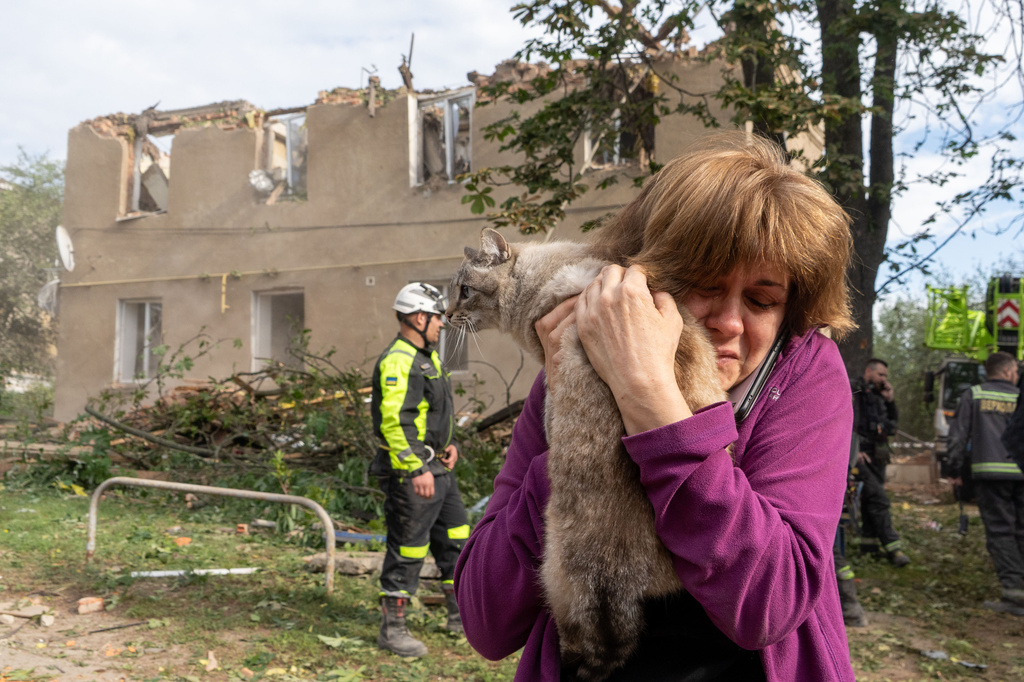 A woman holds her cat after it was found during search and rescue works in the damaged residential building following Russia's missile attack in Kharkiv, Ukraine, Saturday, June 20, 2026. (AP Photo/Andrii Marienko)