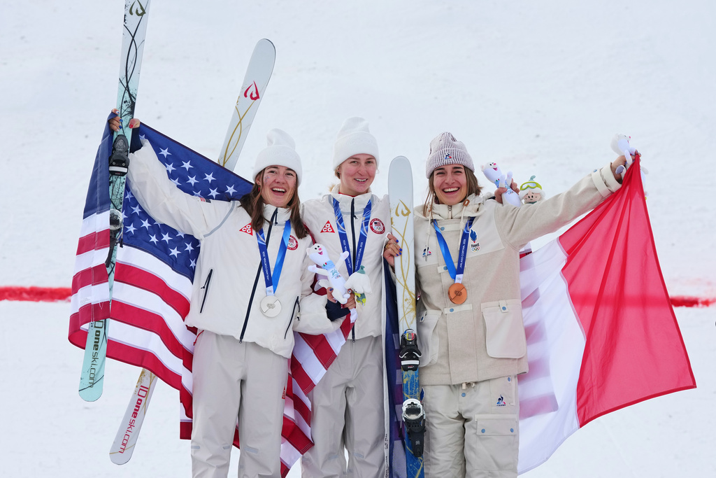 From left, silver medalist United States' Jaelin Kauf, gold medalist United States' Elizabeth Lemley and bronze medalist France's Perrine Laffont celebrate after the women's freestyle skiing moguls finals at the 2026 Winter Olympics, in Livigno, Italy, Wednesday, Feb. 11, 2026. (AP Photo/Gregory Bull)