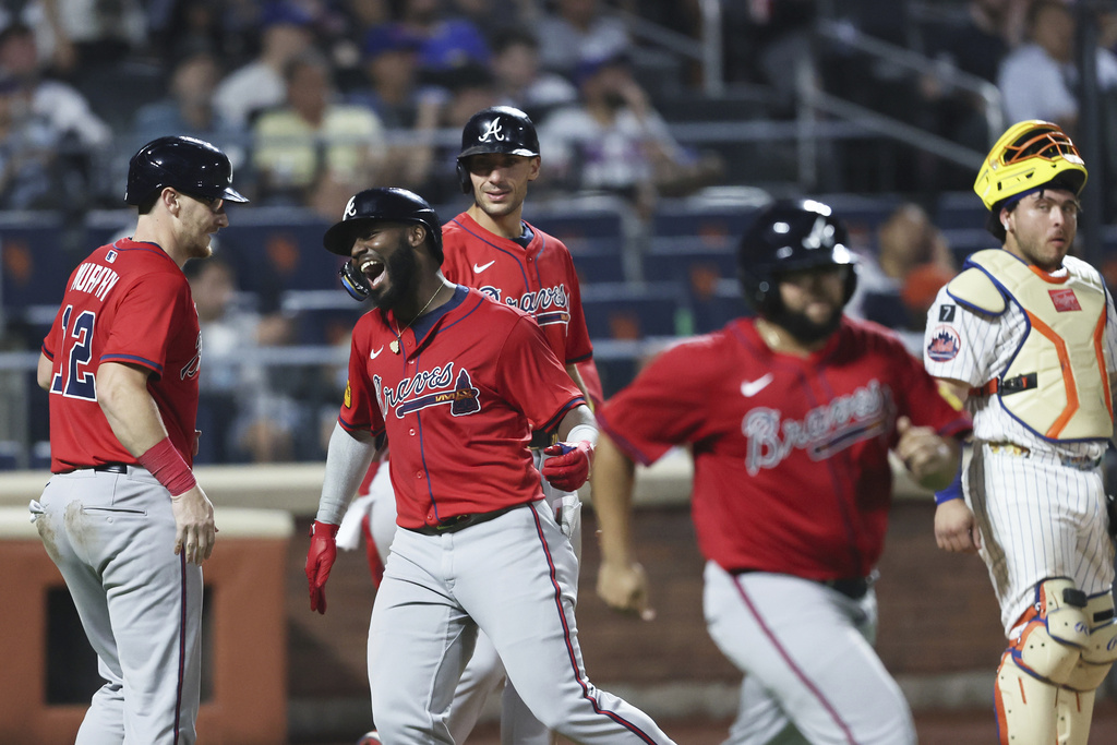 Atlanta Braves' Michael Harris II, center, celebrates his grand slam with Atlanta Braves catcher Sean Murphy (12) while New York Mets catcher Francisco Alvarez looks on during the fourth inning of a baseball game, Wednesday, Aug. 13, 2025, in New York. (AP Photo/Heather Khalifa)