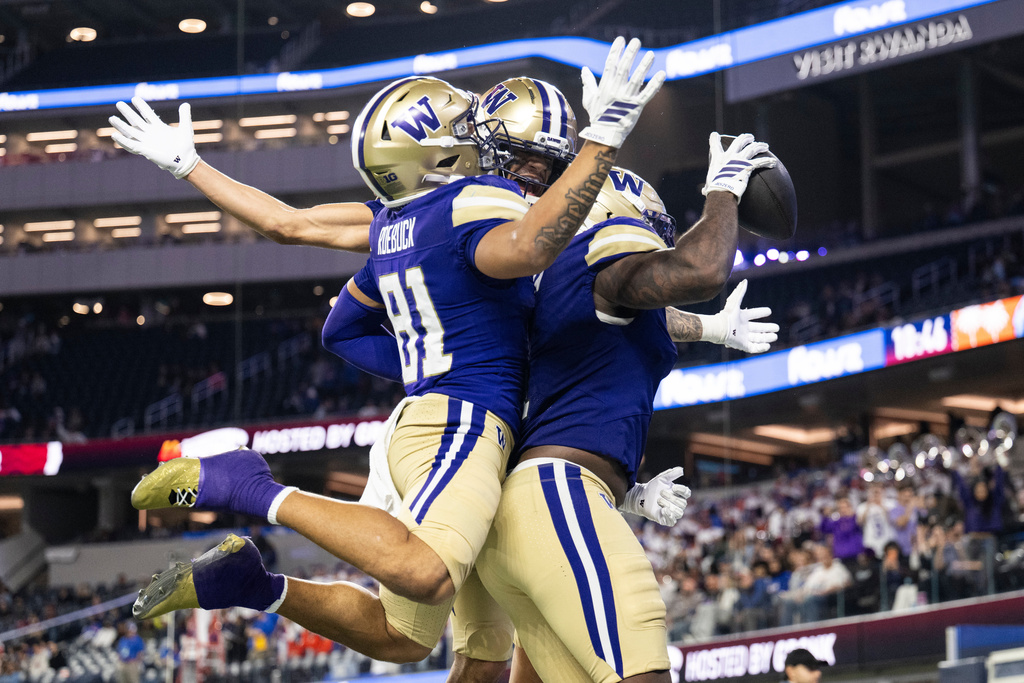 Washington wide receiver Dezmen Roebuck, left, wide receiver Denzel Boston, center, and running back Jonah Coleman celebrate a touchdown by Coleman during the second half of the LA Bowl NCAA college football game against Boise State Saturday, Dec. 13, 2025, in Inglewood, Calif. (AP Photo/Kyusung Gong)