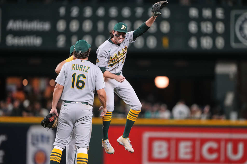 Athletics shortstop Jacob Wilson, right, celebrates a win over the Seattle Mariners with teammates, including Nick Kurtz (16) after a baseball game, Monday, April 20, 2026, in Seattle. (AP Photo/Lindsey Wasson)