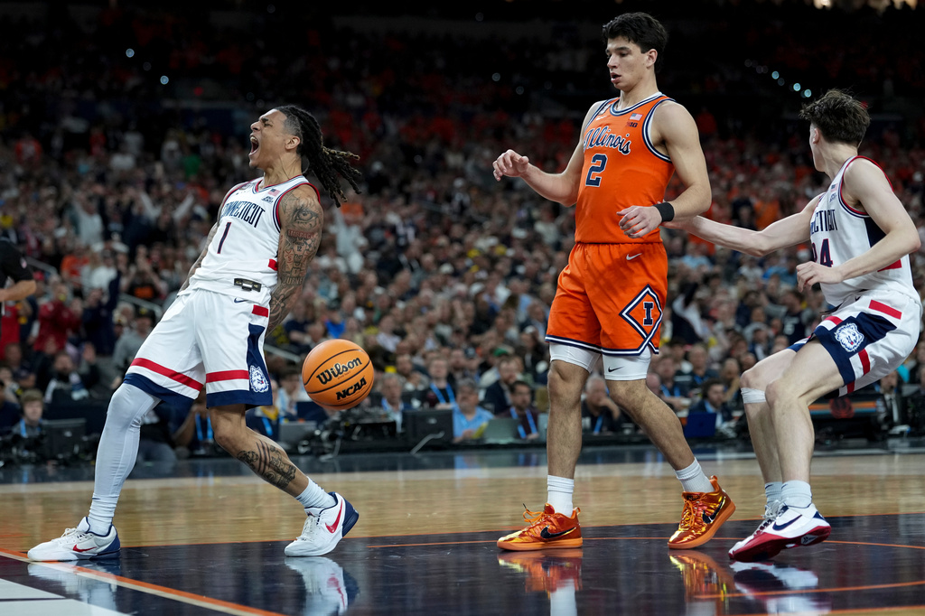 UConn guard Solo Ball (1) celebrates his basket as Illinois guard Andrej Stojakovic (2) looks on during the second half of an NCAA college basketball tournament semifinal game at the Final Four, Saturday, April 4, 2026, in Indianapolis. (AP Photo/Abbie Parr)