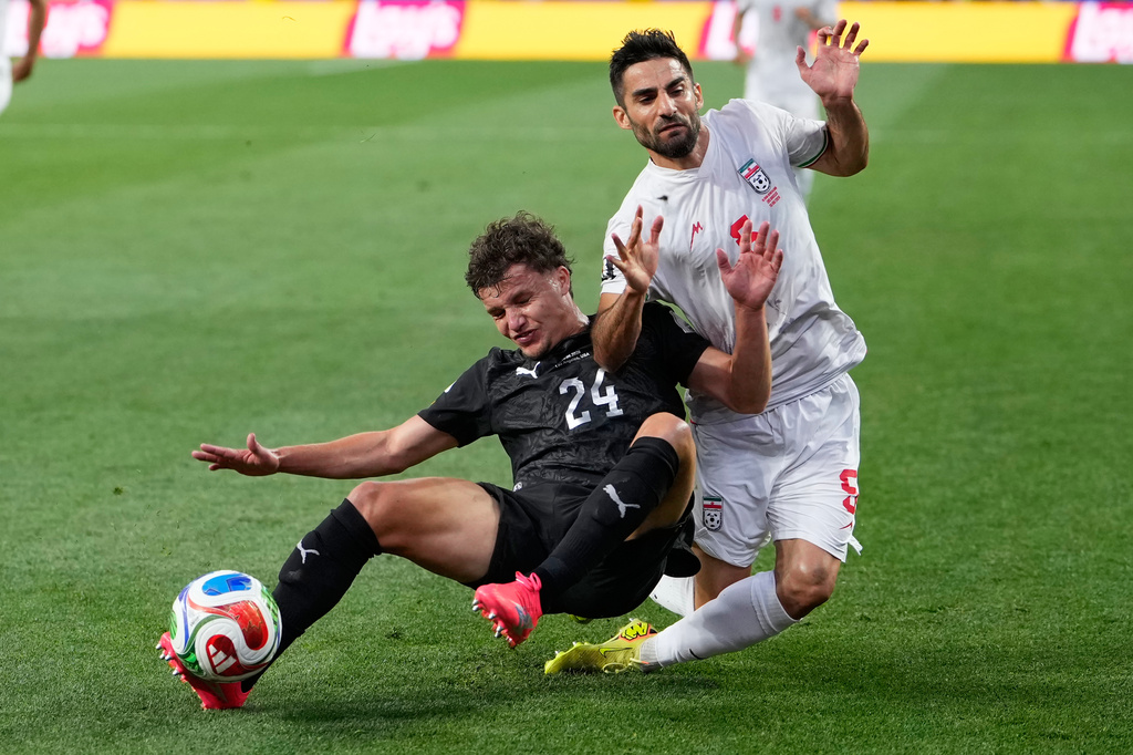 New Zealand's Callan Elliot (24) challenges for the ball with Iran's Milad Mohammadi (5) during the World Cup Group G soccer match between Iran and New Zealand in Inglewood, Calif., near Los Angeles, Monday, June 15, 2026. (AP Photo/Mark J. Terrill)