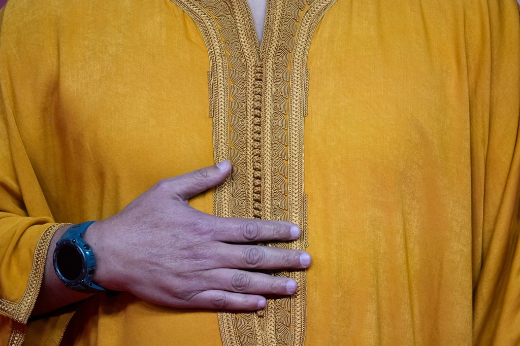 A Moroccan actor wearing a traditional outfit poses for a photo on the red carpet during the 22nd Marrakech Film Festival, in Morocco, Tuesday, Dec. 2, 2025. (AP Photo/Mosa'ab Elshamy)