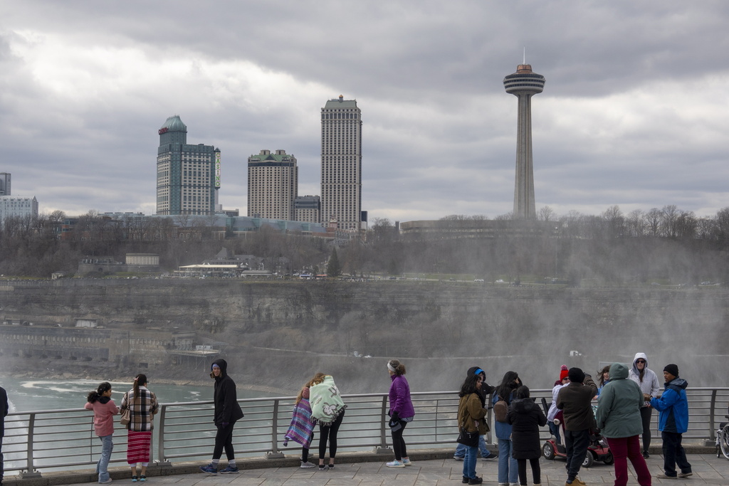 FILE - Tourists on the American side of Niagara Falls take photos in Niagara Falls, N.Y. on March 29, 2024. (Carlos Osorio/The Canadian Press via AP, file)