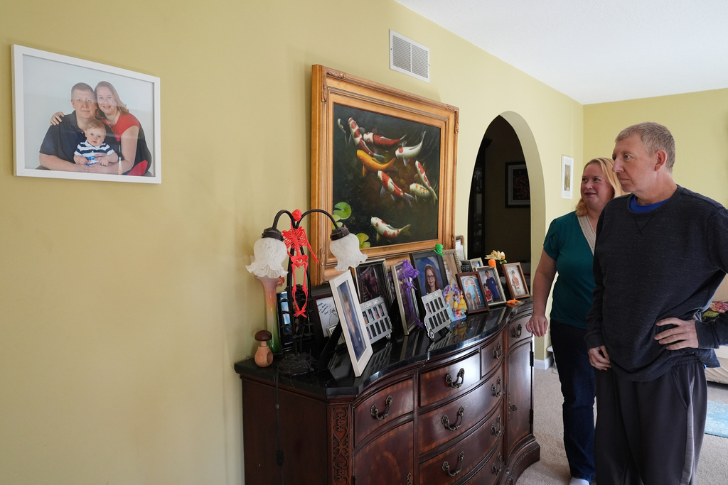 Martha Swick, left, and her husband Bill Swick look at a photo at their home in Minooka, Ill., Friday, Oct. 24, 2025. (AP Photo/Nam Y. Huh)
