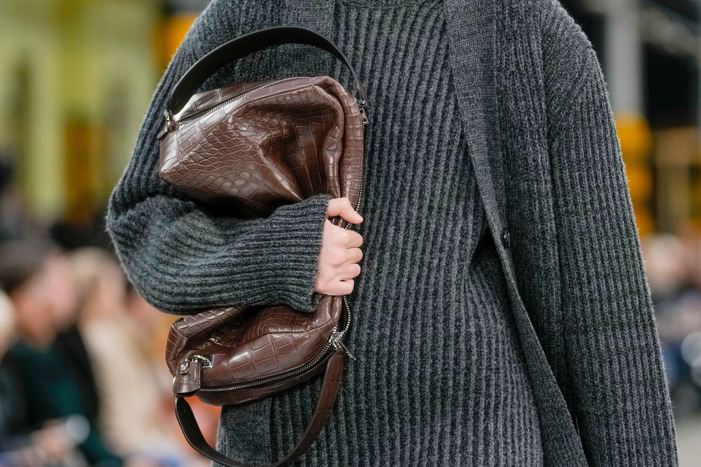 FILE - A model clutches a bag during the Tod's women's Fall-Winter 2024-25 collection presented in Milan, Italy, Friday, Feb. 23, 2024. (AP Photo/Luca Bruno, File)