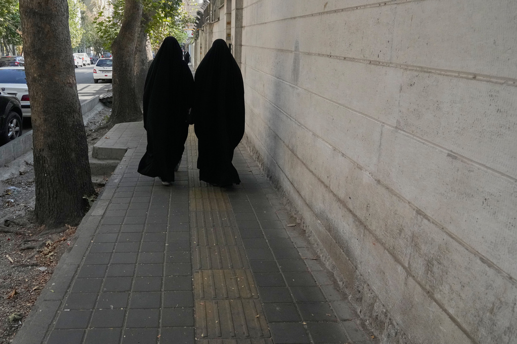 Women walk on a sidewalk in downtown Tehran, Iran, Monday, Aug. 17, 2026. (AP Photo/Vahid Salemi)