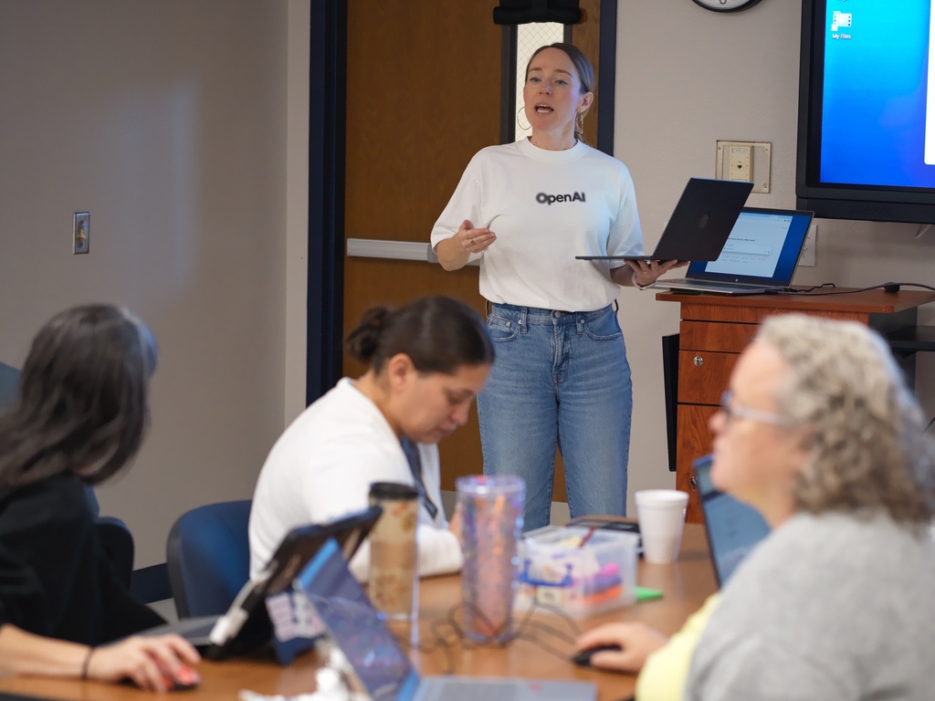 Natalie Cone, head of OpenAI Forum, center, speaks with attendees during a Microsoft AI skilling event, Saturday, Sept. 27, 2025, in San Antonio. (AP Photo/Darren Abate)