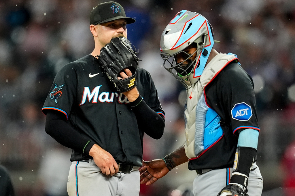 Miami Marlins pitcher Janson Junk (26) speaks with catcher Brian Navarreto in the third inning of a baseball game against the Atlanta Braves, Thursday, Aug. 6, 2026, in Atlanta. (AP Photo/Mike Stewart)