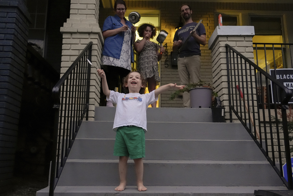 Hannah Hessel, Izzy, Joan and Andrew Ratner bang pots and pans on their porch in protest of President Donald Trump's use of federal law enforcement and National Guard troops in Washington, Wednesday, Aug. 20, 2025, in Washington. (AP Photo/Julia Demaree Nikhinson)