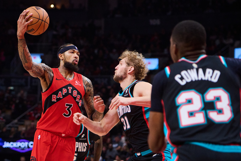 Toronto Raptors' Brandon Ingram (3) drives to the net past Memphis Grizzlies' Jock Landale (31) and Cedric Coward (23) during first-half NBA basketball game action in Toronto, Sunday, Nov. 2, 2025. (Sammy Kogan/The Canadian Press via AP)