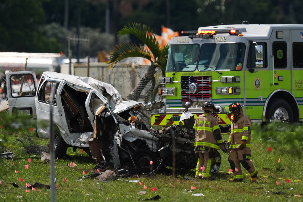 Miami Dade Fire Rescue officials inspect a damaged vehicle two days after an Amazon cargo plane overshot a runway at Miami International Airport, Tuesday, Sept. 8, 2026, in Miami. (AP Photo/Rebecca Blackwell)