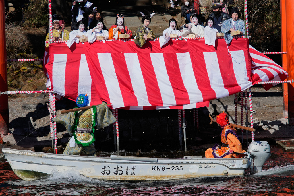 Locals dressed as Japanese folklore figures throw lucky beans to 'Oni', or demon-like figures, at Lake Ashi near Hakone Shrine during the annual Bean Throwing Festival in Hakone, Japan, Tuesday, Feb. 3, 2026. (AP Photo/Eugene Hoshiko)