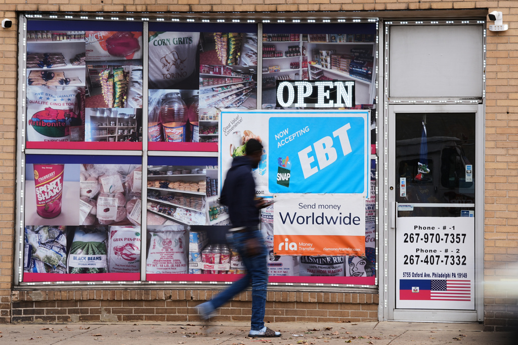 A customer walks past an EBT payment sign posted on the front window of a grocery store in Philadelphia, Wednesday, Oct. 29, 2025. (AP Photo/Matt Rourke)