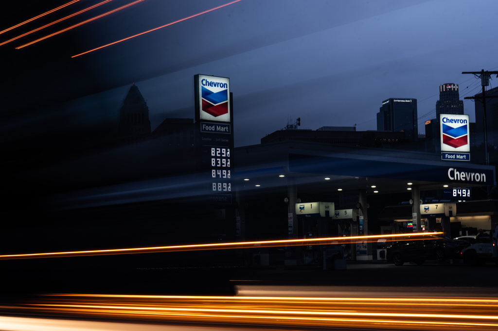 In this photo taken with a slow shutter speed, a truck passes by gas prices that are displayed at a Chevron gas station, in downtown Los Angeles, Tuesday, March 31, 2026. (AP Photo/Jae C. Hong)