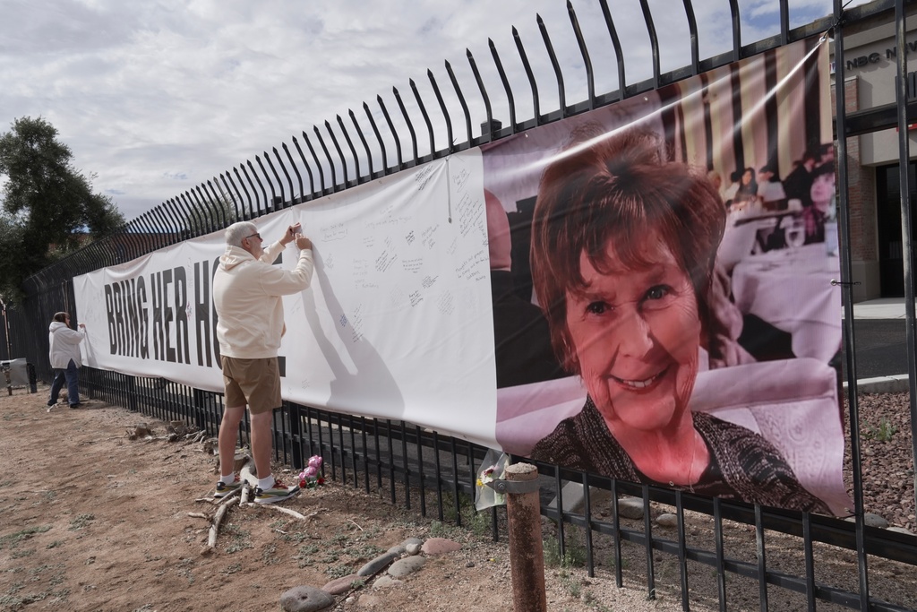 Jeff Robb, a Seattle resident wintering in Tucson, signs a banner supporting Nancy Guthrie in Tucson Ariz., on Friday, Feb. 13, 2026. (AP Photo/Ty ONeil)