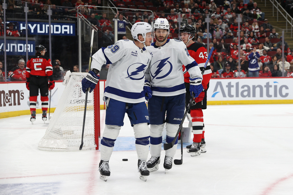 Tampa Bay Lightning's Jake Guentzel (59) reacts with Oliver Bjorkstrand (22) after scoring a goal against the New Jersey Devils during the first period of an NHL hockey game Thursday, Dec. 11, 2025, in Newark, N.J. (AP Photo/Pamela Smith)