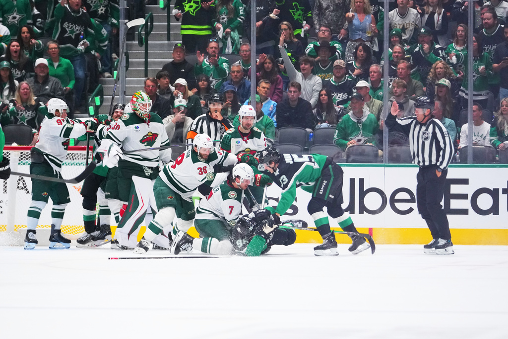 Dallas Stars right wing Mikko Rantanen (96) is dropped to the ice while scuffling with Minnesota Wild players during the second period in Game 1 of a first-round NHL Stanley Cup playoffs hockey series, Saturday, April 18, 2026, in Dallas, Texas. (AP Photo/Julio Cortez)